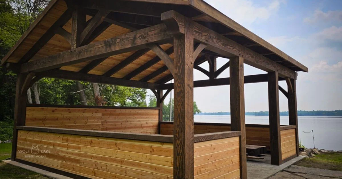 Timber frame pavilion overlooking lake in summer