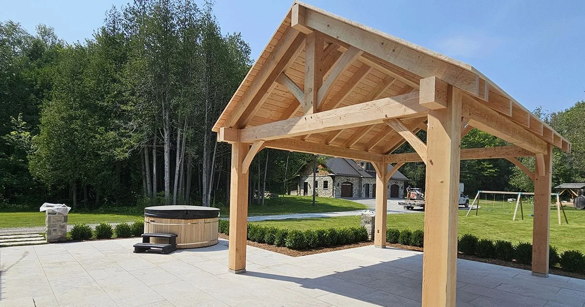 Natural wood timber frame pavilion with hot tub on landscaped patio